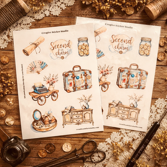 Two sheets of 'Second in Charm' stickers on a wooden surface with decorative items.