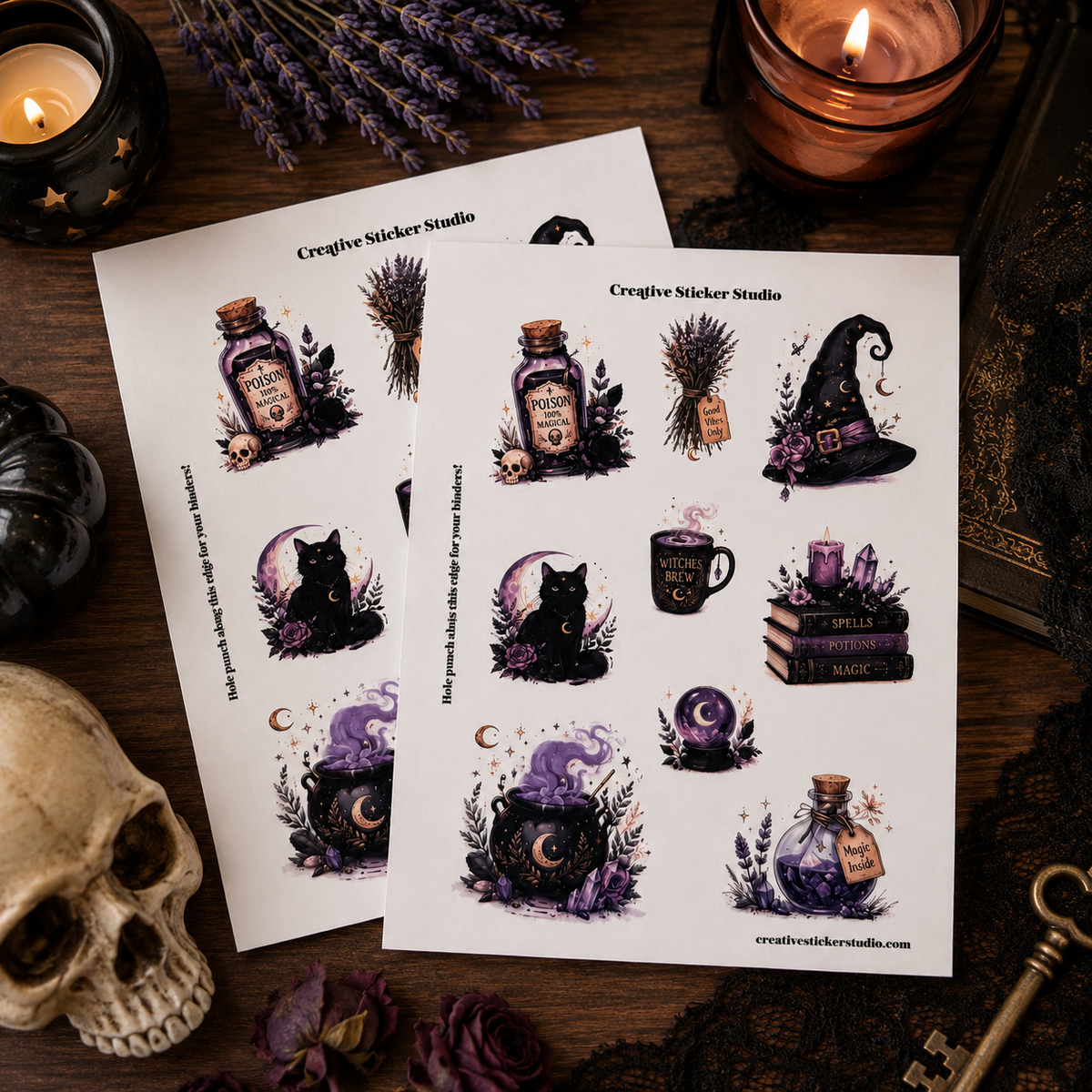 Two sheets of witch-themed sticker designs displayed on a dark wooden surface surrounded by Halloween decor, including a skull, candle, lavender, and key. The stickers feature a black cat, potion bottle, cauldron, witch hat, and spells on a white background.