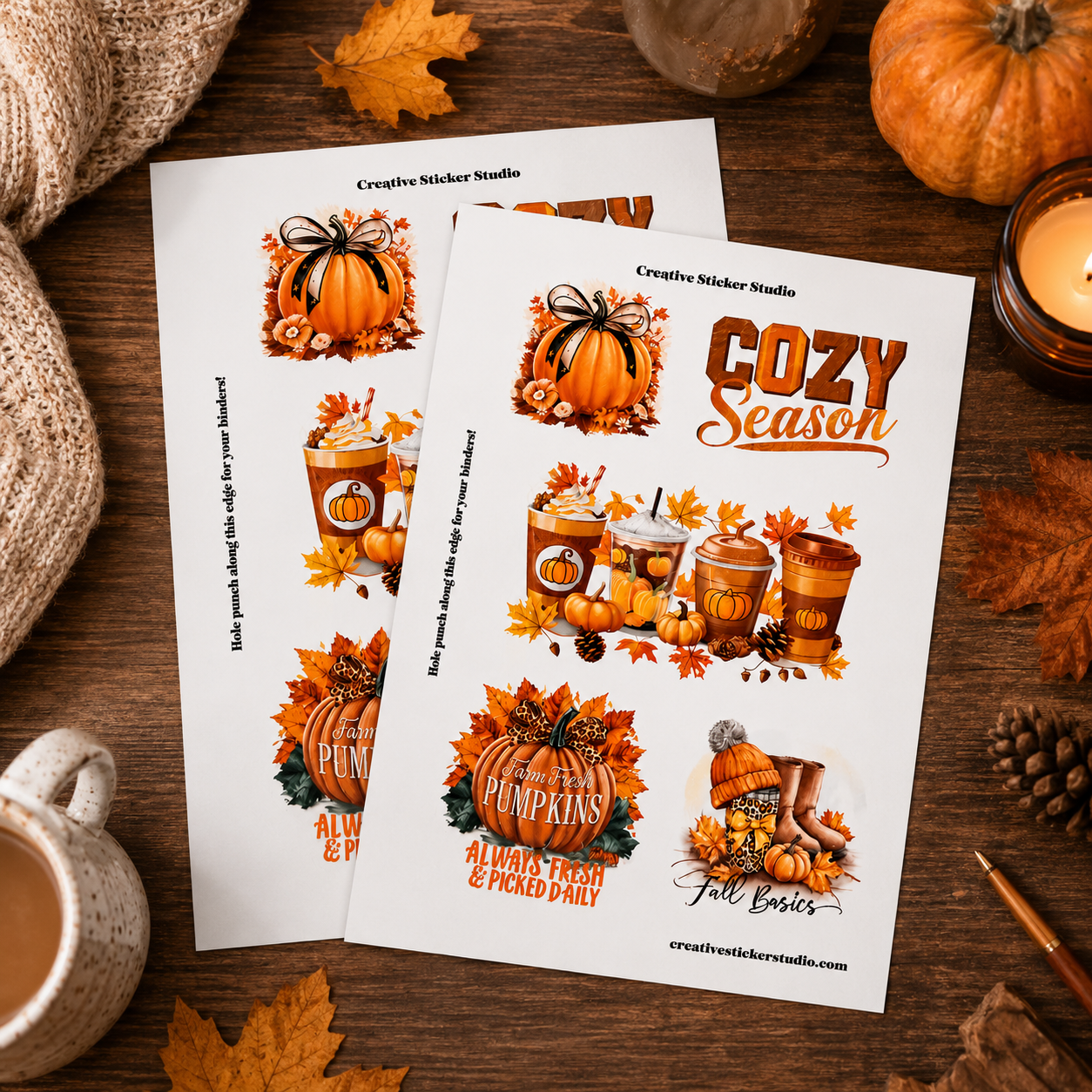 Two printed sticker sheets displayed on a rustic wooden surface with autumn props, featuring fall-themed illustrations such as pumpkins, leaves, coffee cups, and the text 'Cozy Season' and 'Creative Sticker Studio'.