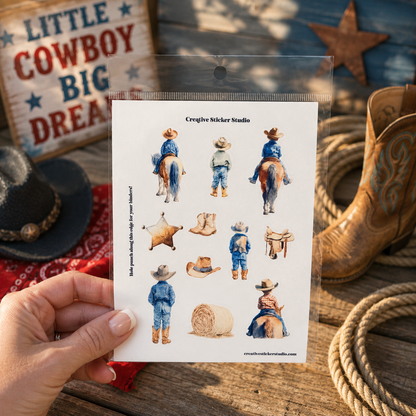 A hand holds a clear plastic bag containing a sheet of cowboy-themed sticker designs, including figures in blue jeans and boots, hats, a lasso, and western accessories. The background is a rustic wooden surface with a cowboy hat, bandana, rope, and a western sign.